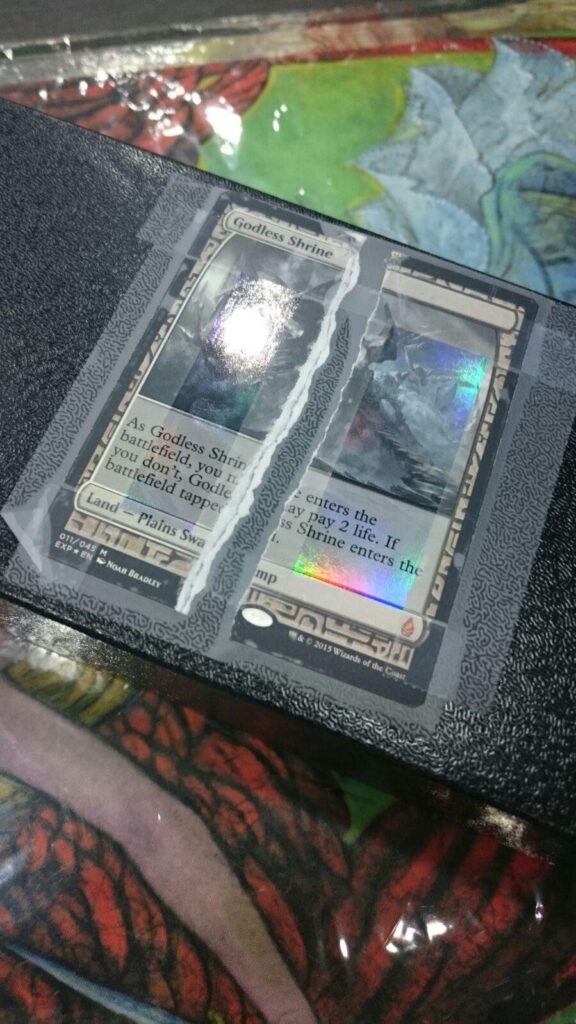 A damaged copy of Godless Shrine from Battle For Zendikar's Expedition series. Yet another casualty of Flip It.
